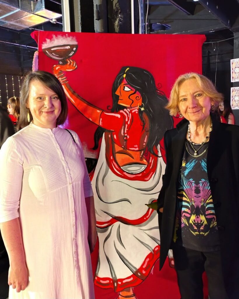 Two 2026 laureates standing together in front of a painted artwork